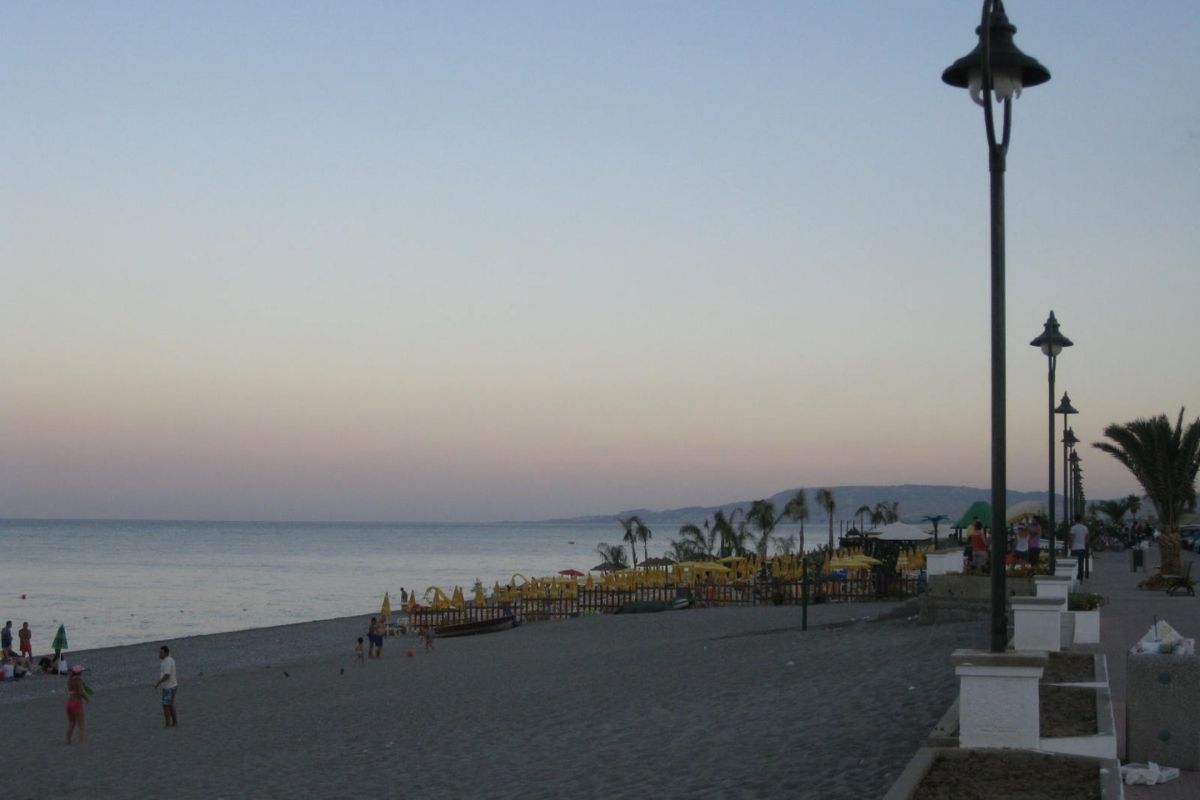 Vista del lungomare di Locri al tramonto, con persone che passeggiano